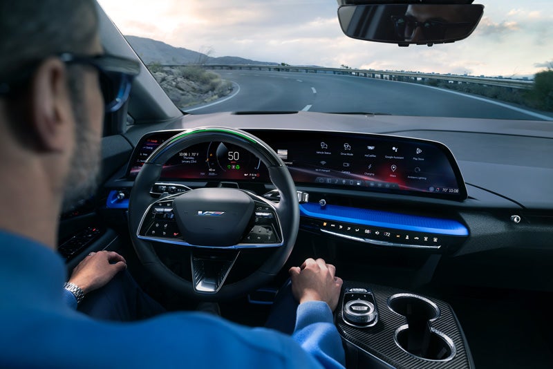 Front View of the 2026 OPTIQ-V Driving Through the Dusk Utilizing its Headlights | McGuire Cadillac in Woodbridge NJ